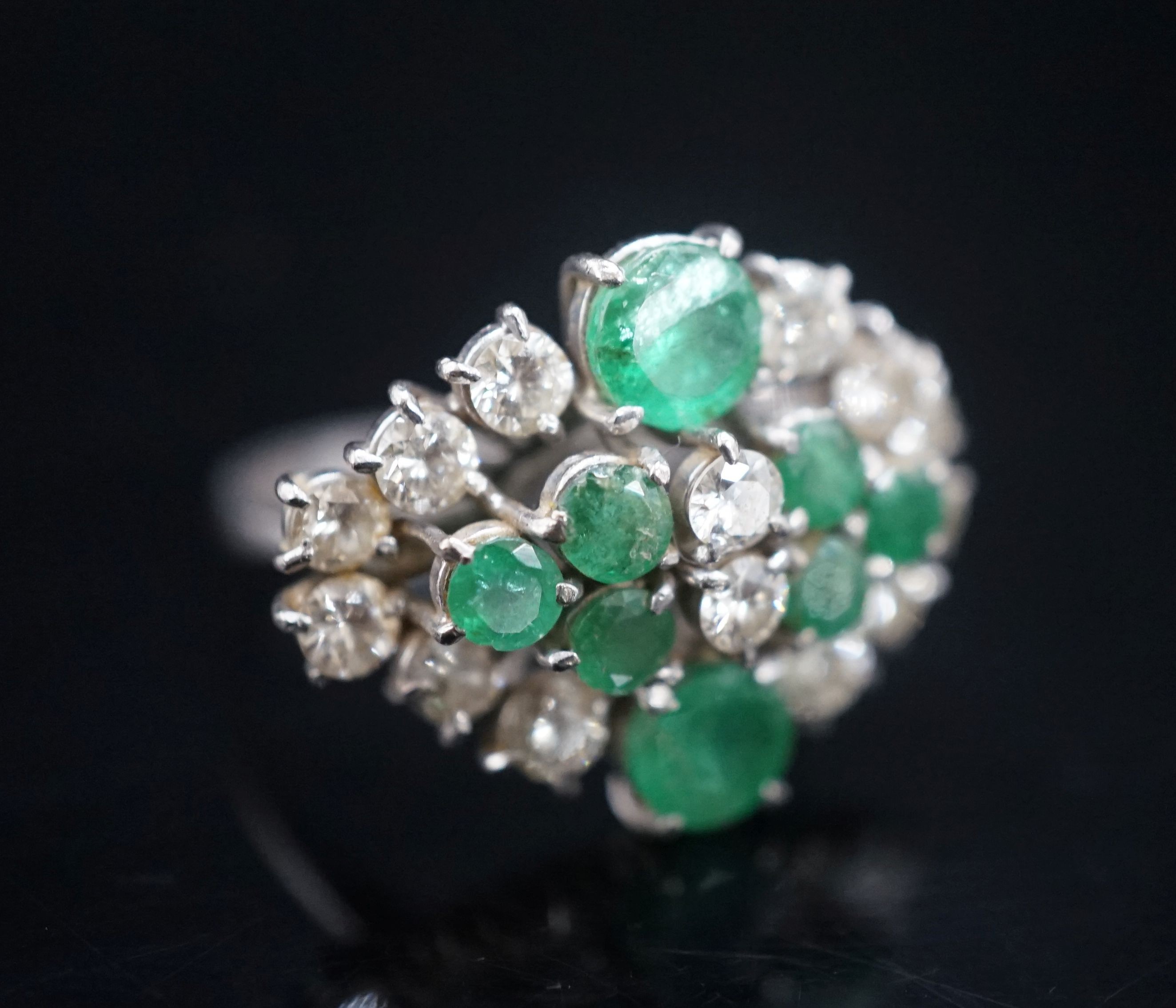 A 20th century 18ct white metal, emerald and diamond set cluster dress ring, size O/P, gross weight 7.3 grams.